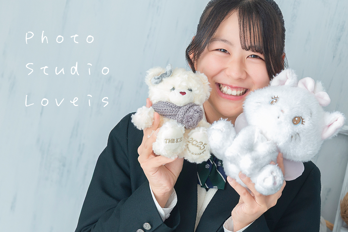 富士河口湖町の写真スタジオでぬいぐるみと一緒に卒業記念撮影をする笑顔の女子高生